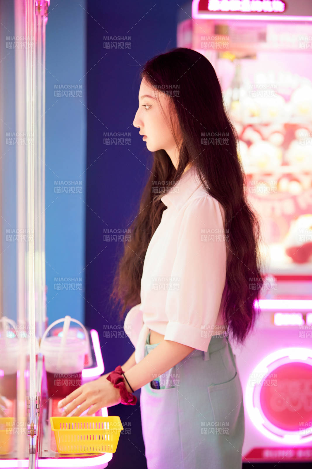 在電子游戲娛樂城玩抓娃娃機的時尚少女