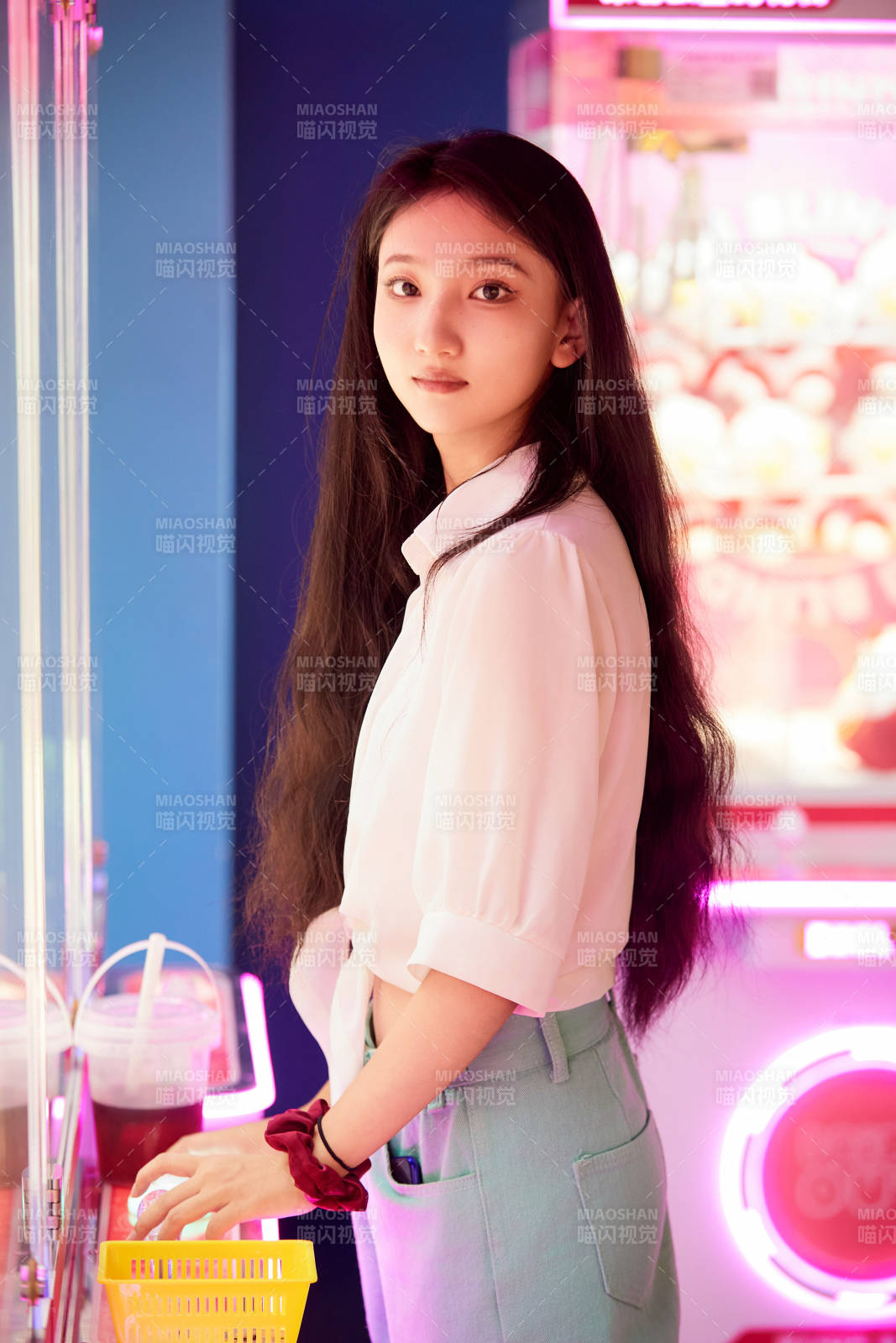 在電子游戲娛樂城玩抓娃娃機的時尚少女