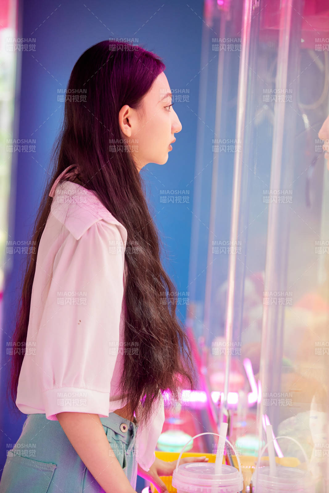 在電子游戲娛樂城玩抓娃娃機的時尚少女