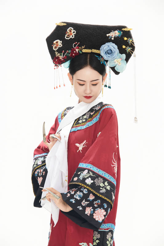 白色背景下穿着中国清朝宫廷服饰的少女