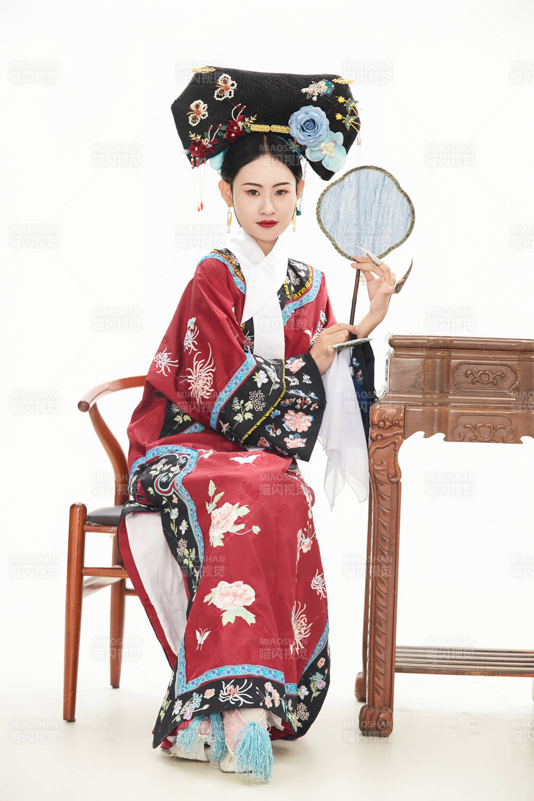 白色背景下穿着中国清朝宫廷服饰的少女