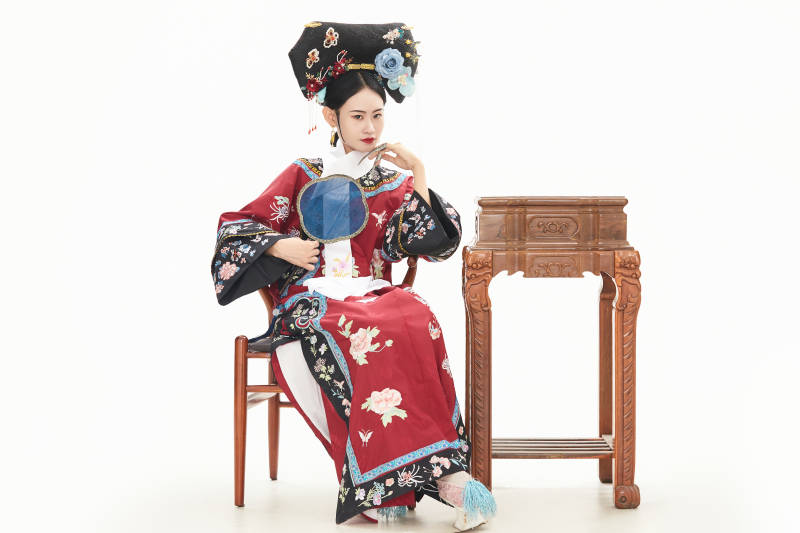 白色背景下穿着中国清朝宫廷服饰的少女