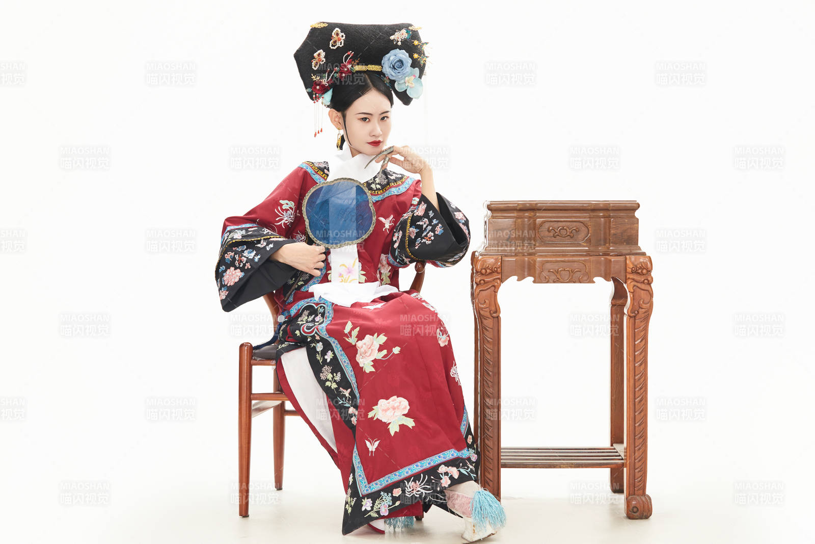 白色背景下穿着中国清朝宫廷服饰的少女