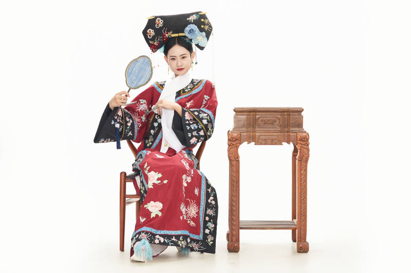 白色背景下穿着中国清朝宫廷服饰的少女