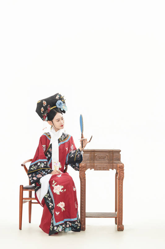 白色背景下穿着中国清朝宫廷服饰的少女