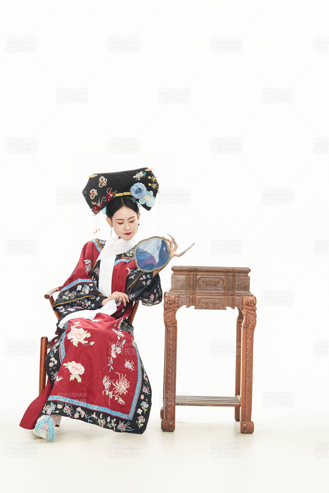 白色背景下穿着中国清朝宫廷服饰的少女