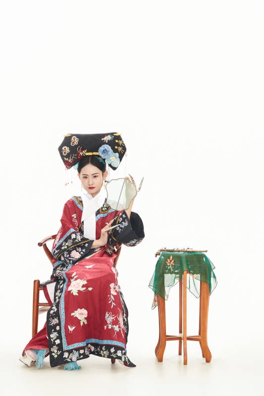 白色背景下穿着中国清朝宫廷服饰的少女