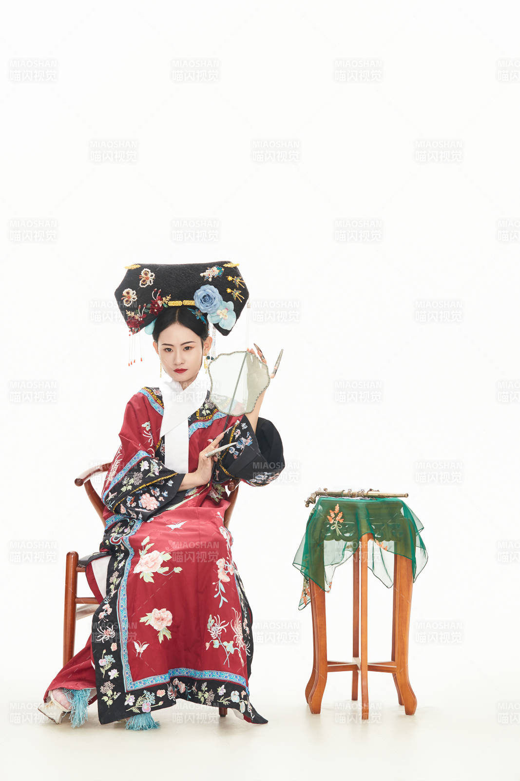 白色背景下穿着中国清朝宫廷服饰的少女