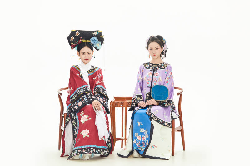 白色背景下穿著中國清朝服飾的兩名少女