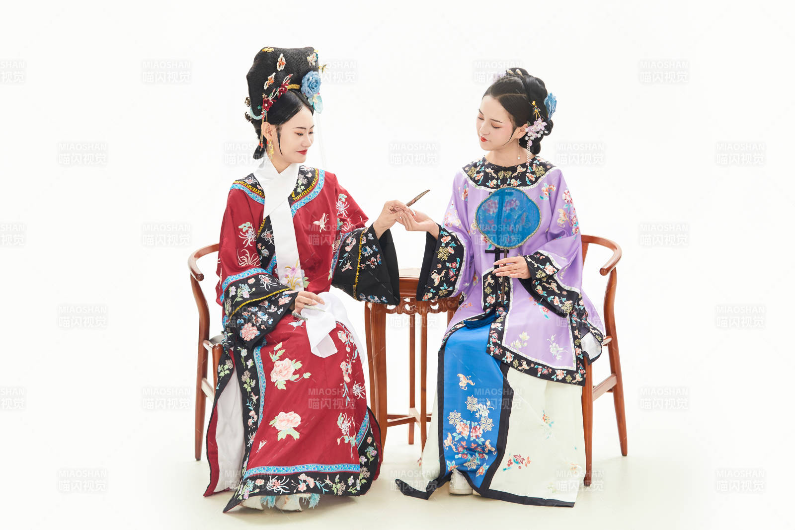 白色背景下穿着中国清朝服饰的两名少女