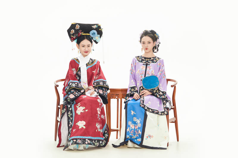 白色背景下穿着中国清朝服饰的两名少女