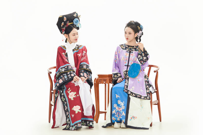 白色背景下穿著中國清朝服飾的兩名少女