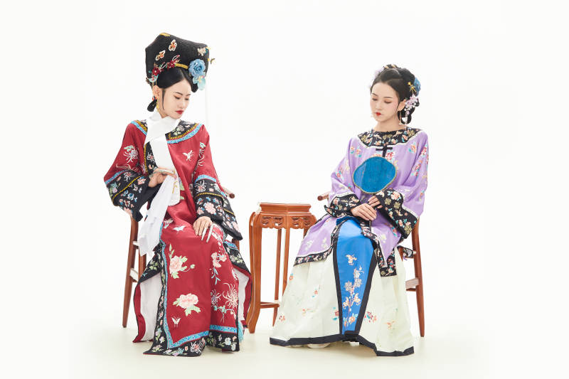 白色背景下穿著中國清朝服飾的兩名少女