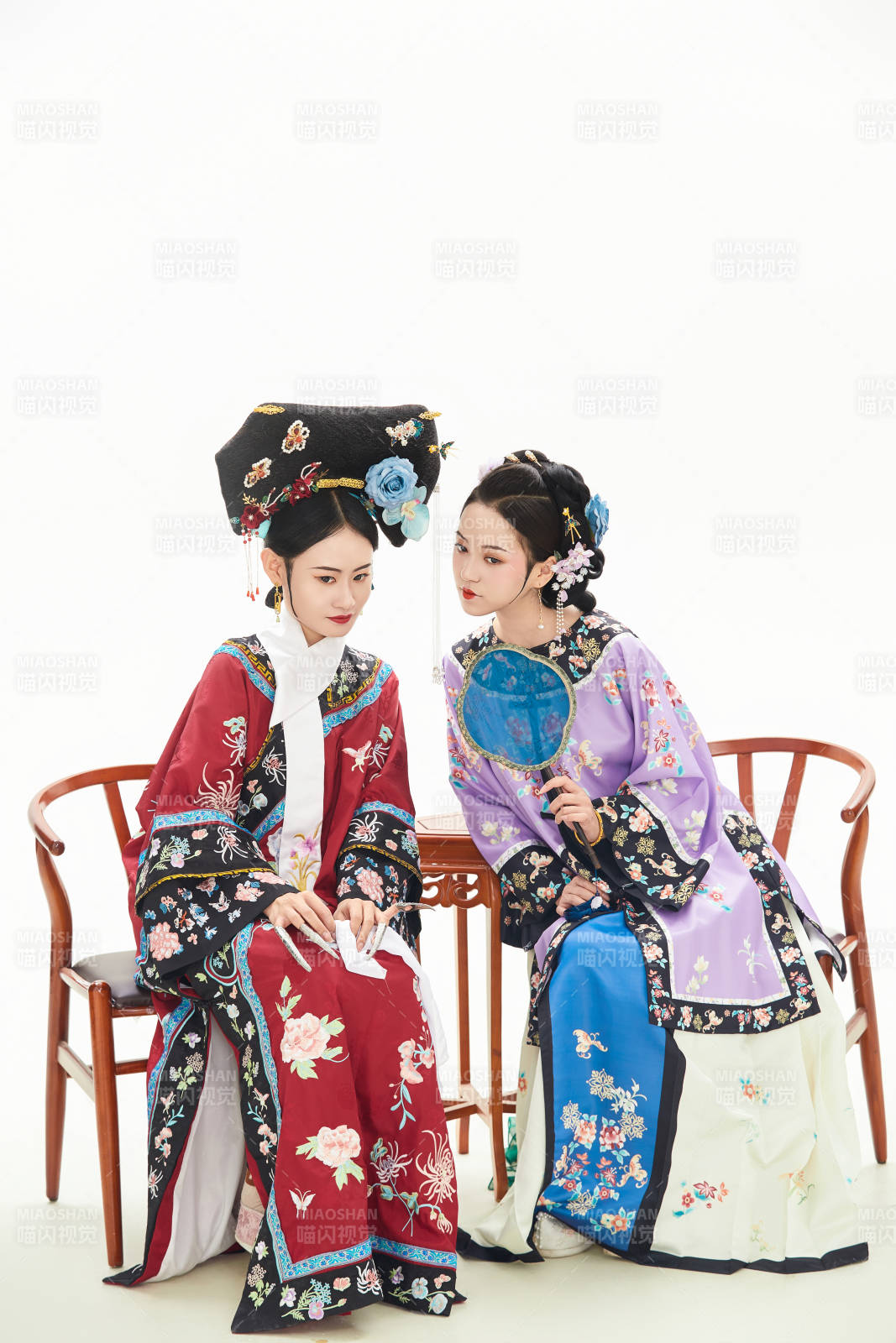 白色背景下穿着中国清朝服饰的两名少女图片