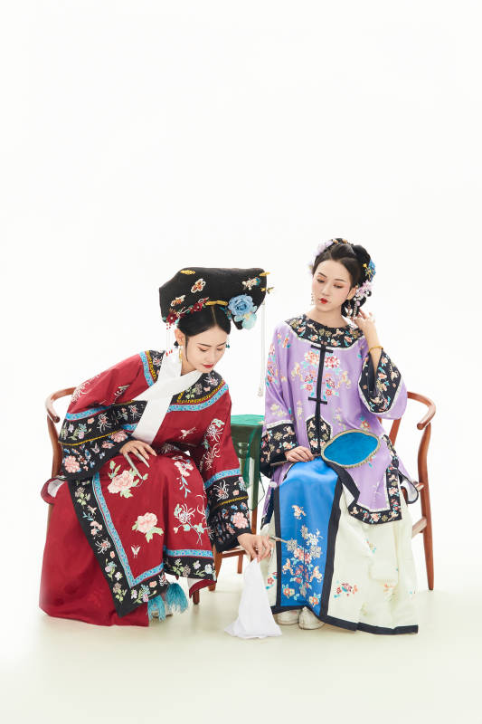 白色背景下穿着中国清朝服饰的两名少女