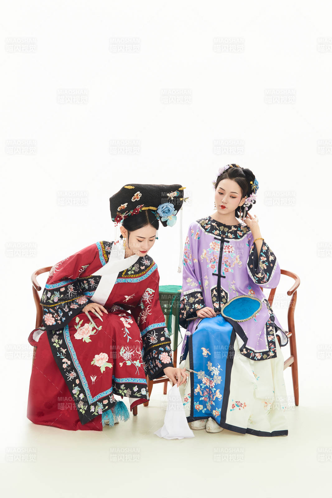 白色背景下穿着中国清朝服饰的两名少女