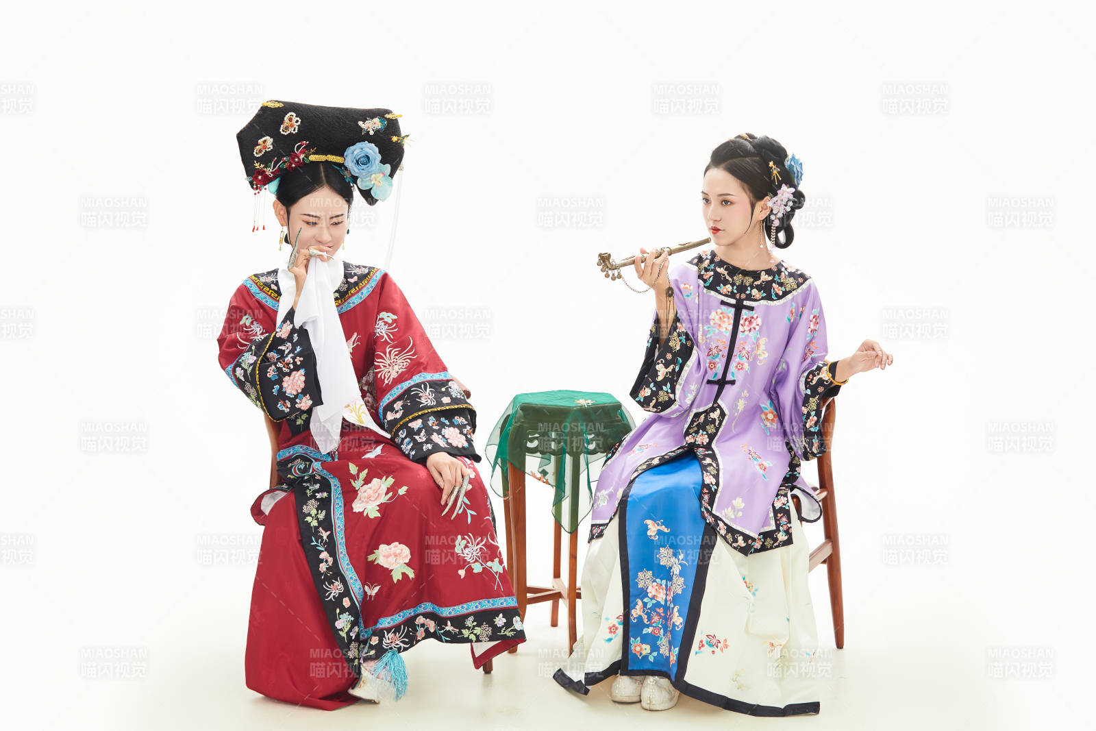 白色背景下穿著中國清朝服飾的兩名少女