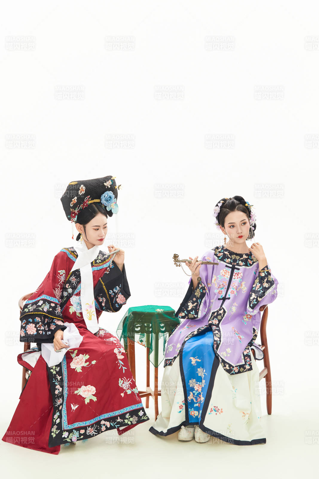 白色背景下穿著中國清朝服飾的兩名少女