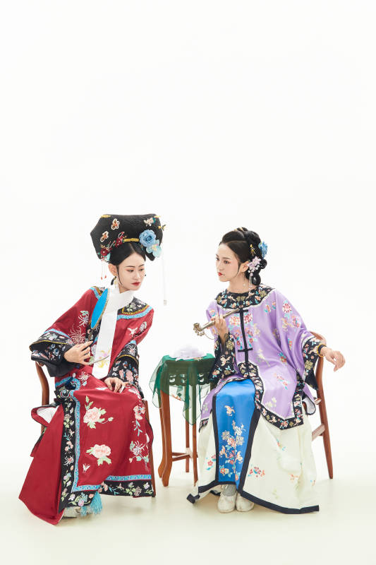白色背景下穿着中国清朝服饰的两名少女