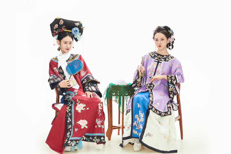 白色背景下穿著中國清朝服飾的兩名少女