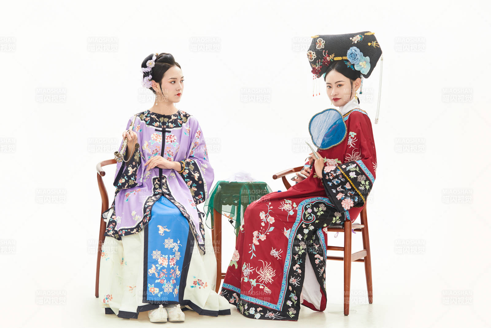 白色背景下穿著中國清朝服飾的兩名少女