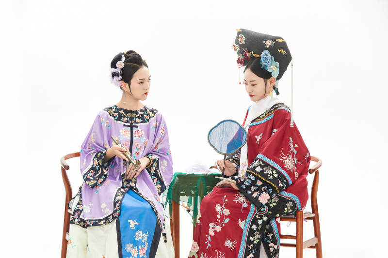 白色背景下穿着中国清朝服饰的两名少女