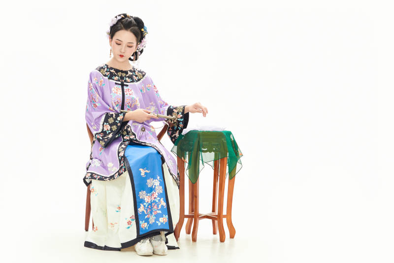 白色背景下穿著中國清朝晚清服飾的少女
