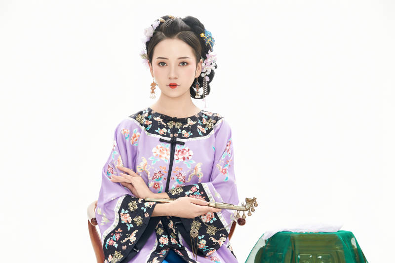 白色背景下穿著中國清朝晚清服飾的少女