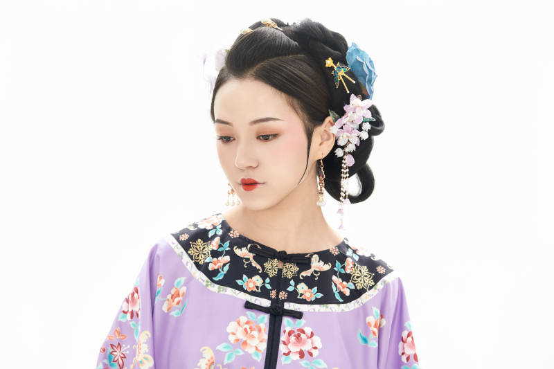 白色背景下穿著中國清朝晚清服飾的少女