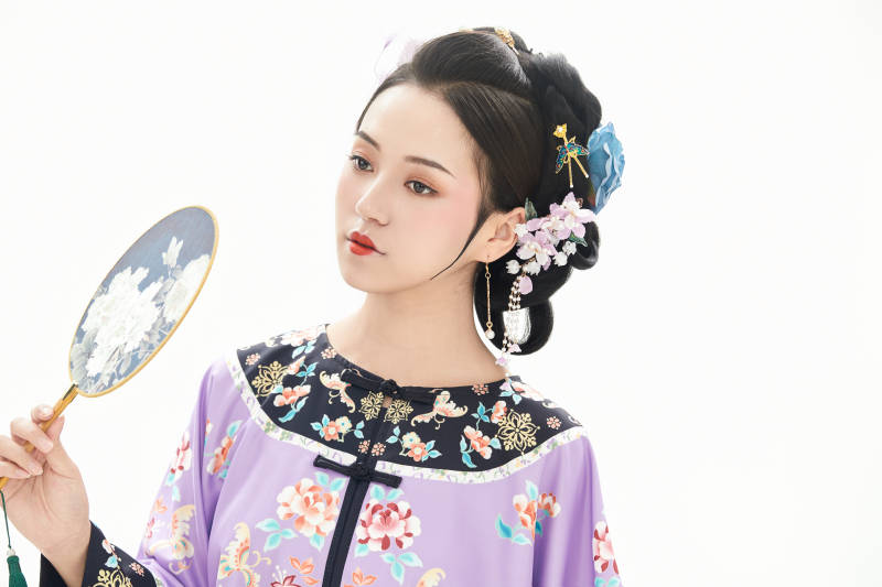 白色背景下穿著中國清朝晚清服飾的少女