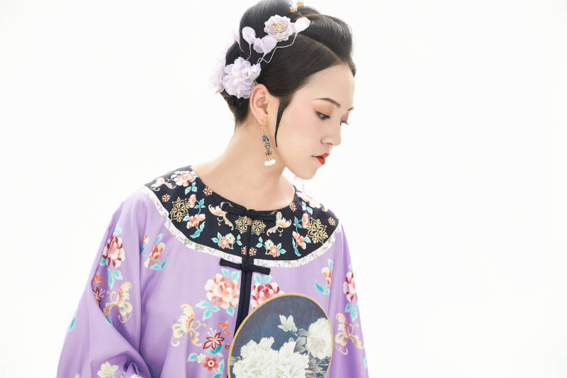 白色背景下穿著中國清朝晚清服飾的少女