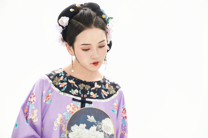 白色背景下穿著中國清朝晚清服飾的少女