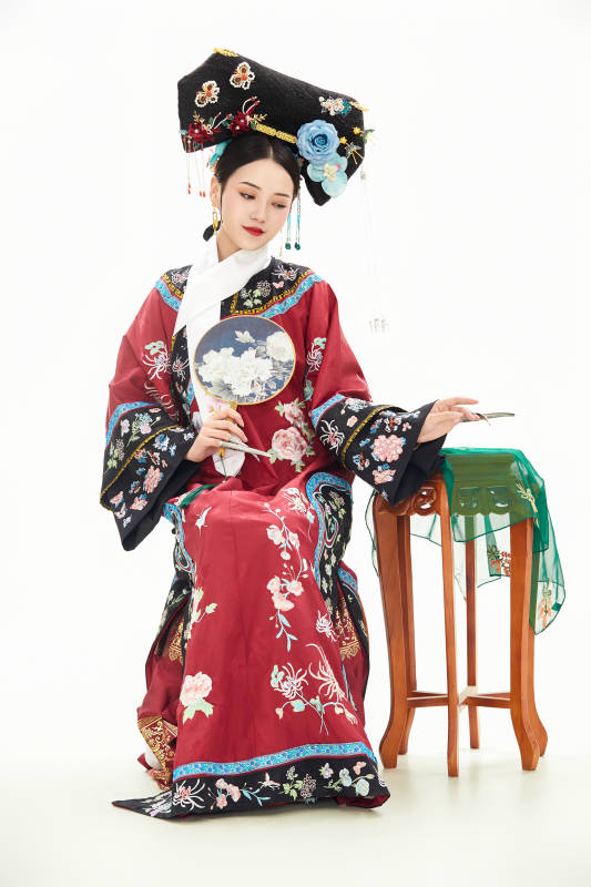 白色背景下穿着中国清朝宫廷服饰的少女