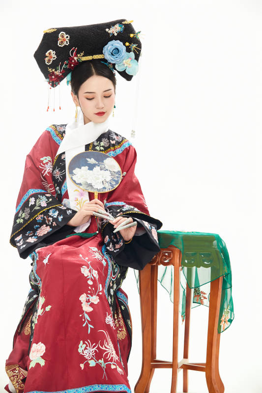 白色背景下穿着中国清朝宫廷服饰的少女