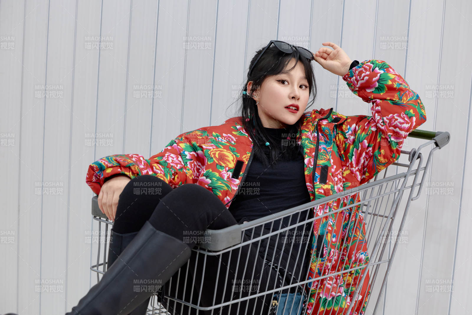 坐在商场超市购物车拍照玩乐的亚洲美女