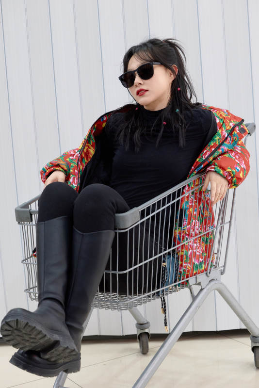 坐在商场超市购物车拍照玩乐的亚洲美女