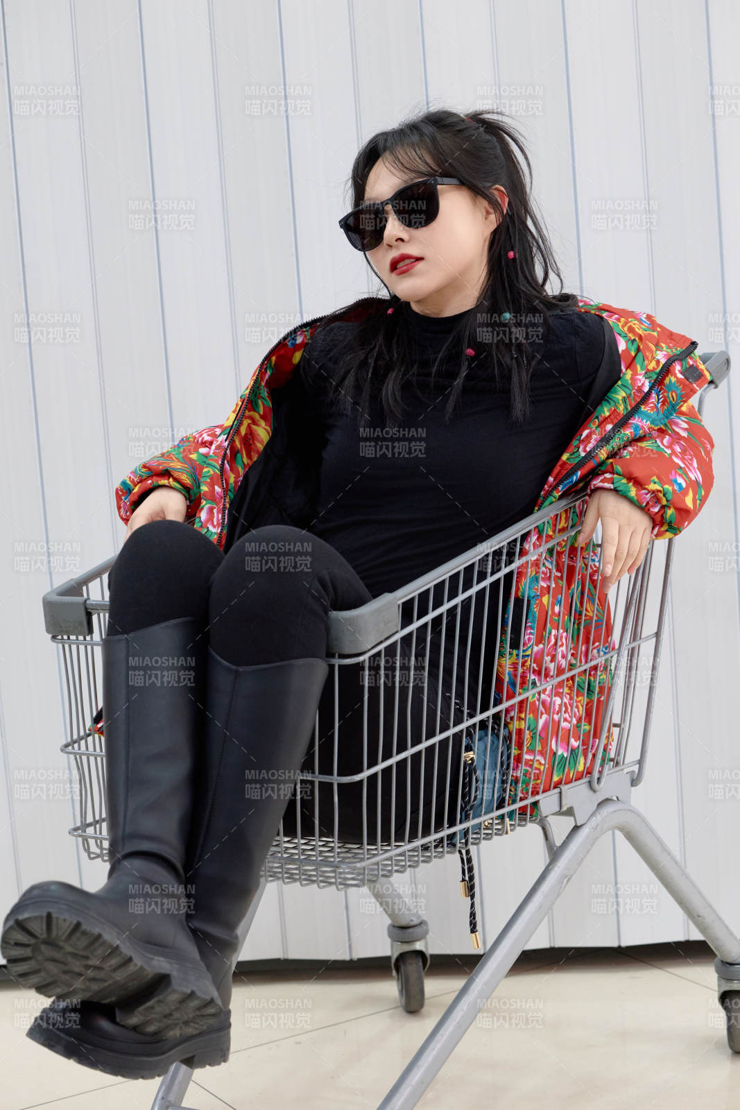 坐在商场超市购物车拍照玩乐的亚洲美女