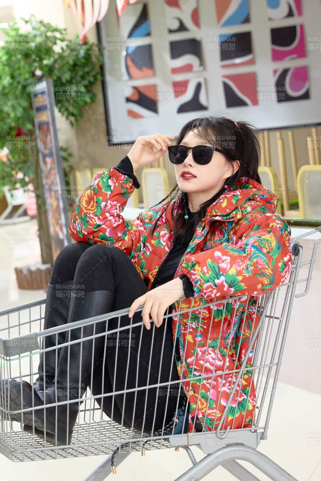 坐在商場超市購物車拍照玩樂的亞洲美女