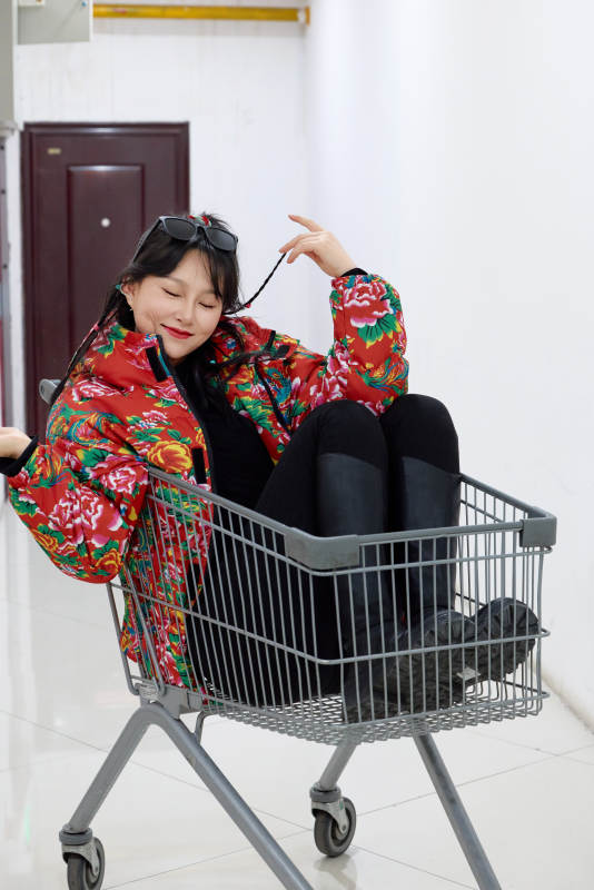 坐在商场超市购物车拍照玩乐的亚洲美女