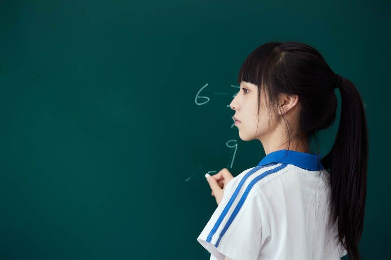 上课时在教室黑板解答数学习题的高中生