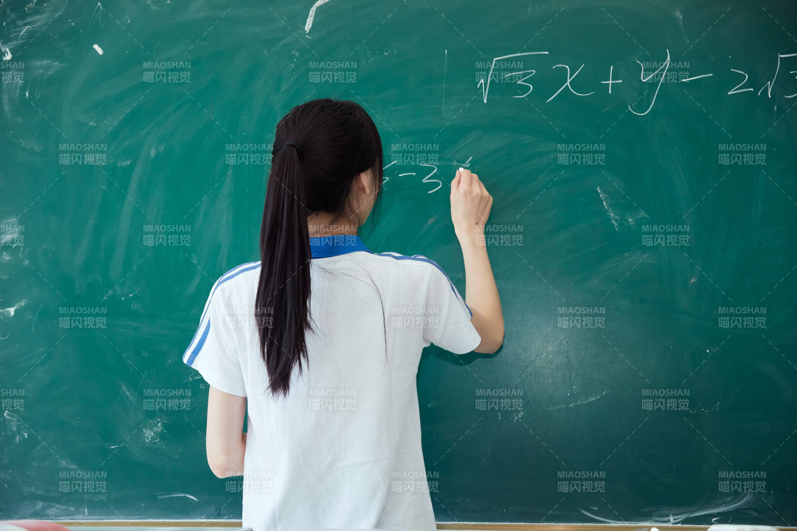 上课时在教室黑板解答数学习题的高中生