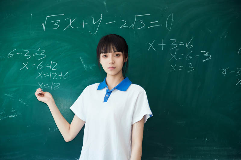 上课时在教室黑板解答数学习题的高中生
