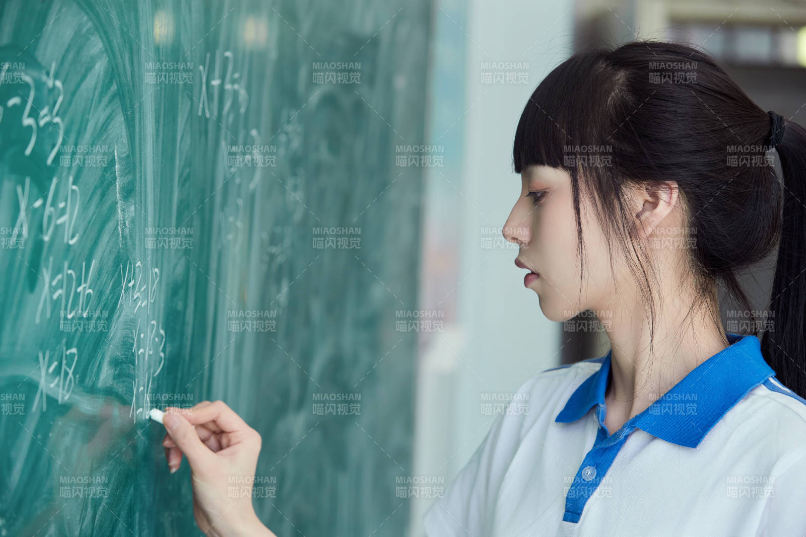 上课时在教室黑板解答数学习题的高中生