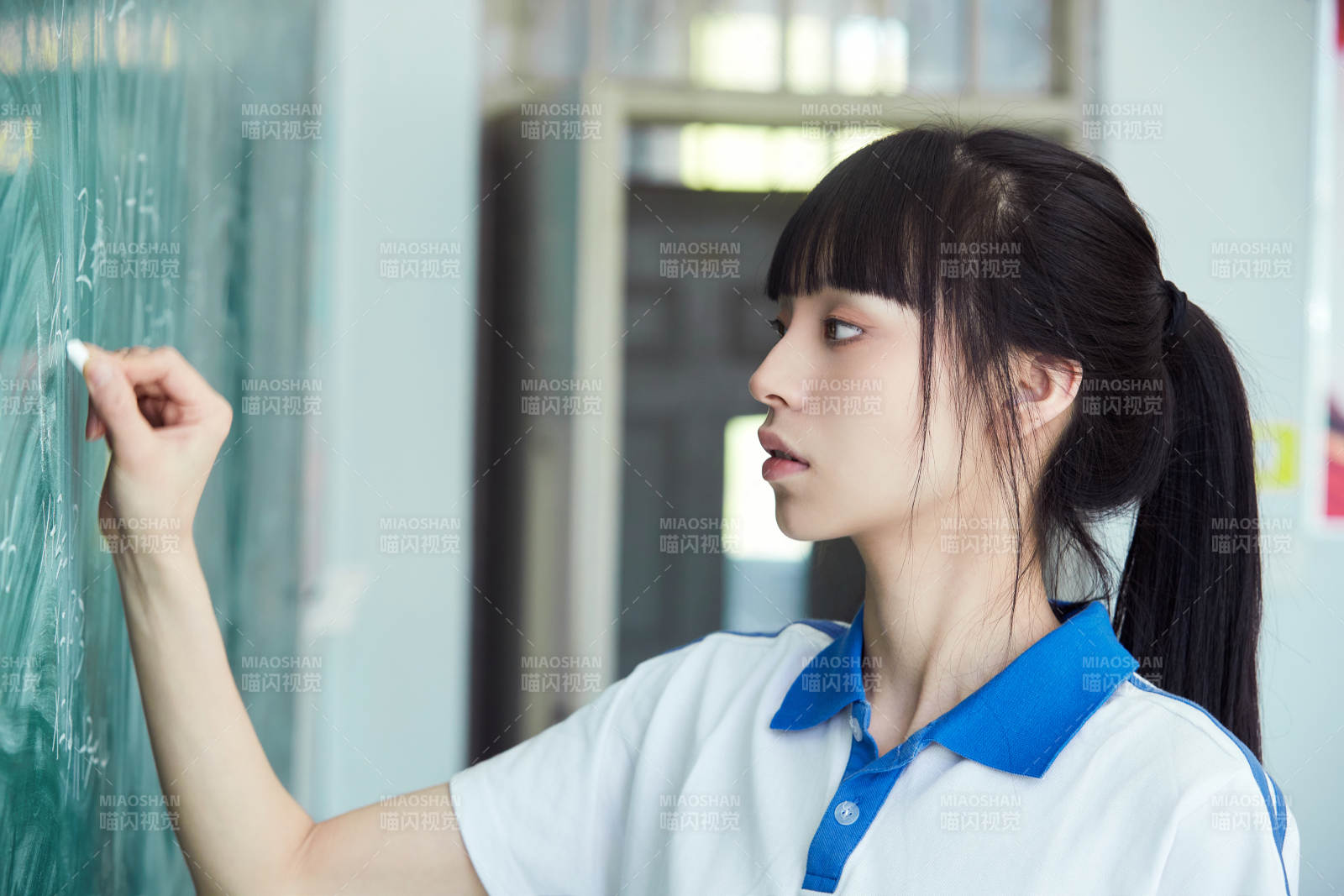 上课时在教室黑板解答数学习题的高中生