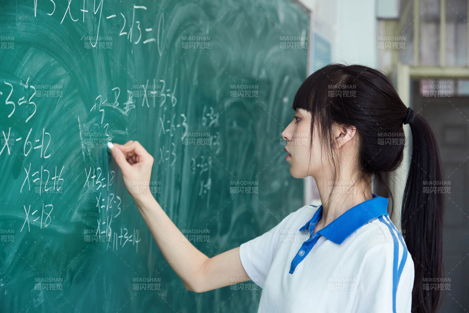 上课时在教室黑板解答数学习题的高中生