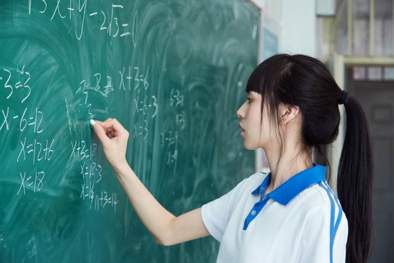 上课时在教室黑板解答数学习题的高中生