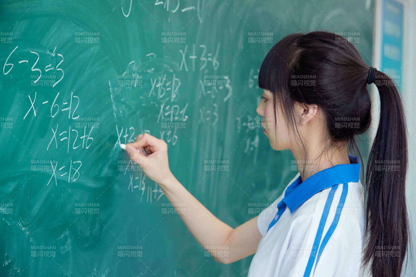 上课时在教室黑板解答数学习题的高中生