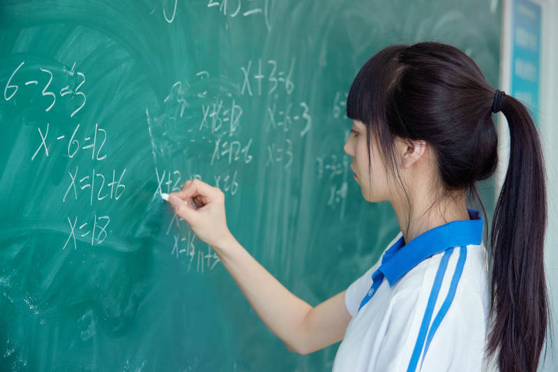 上课时在教室黑板解答数学习题的高中生