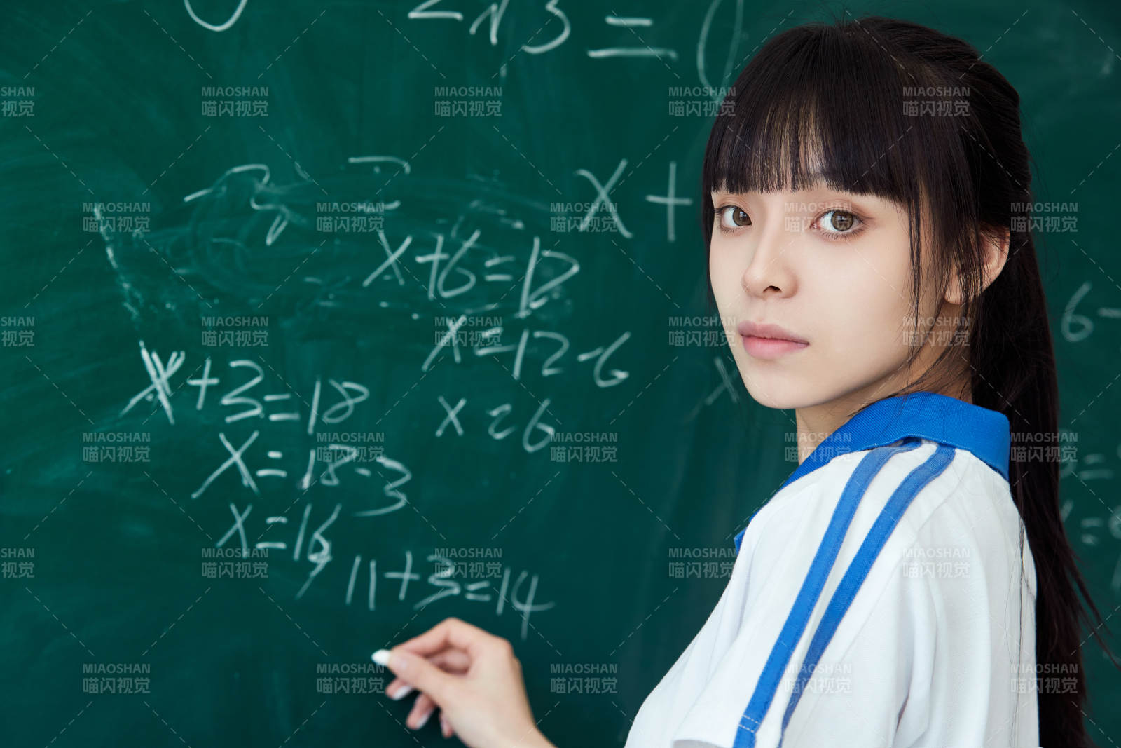 上课时在教室黑板解答数学习题的高中生