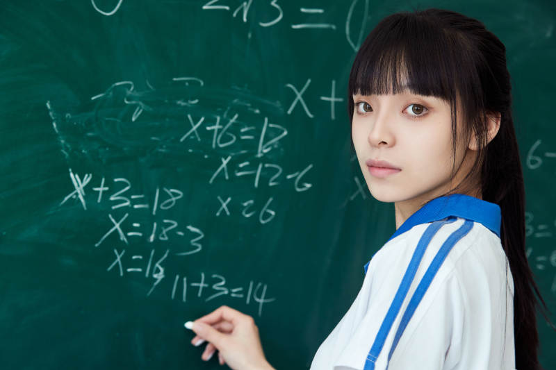上课时在教室黑板解答数学习题的高中生